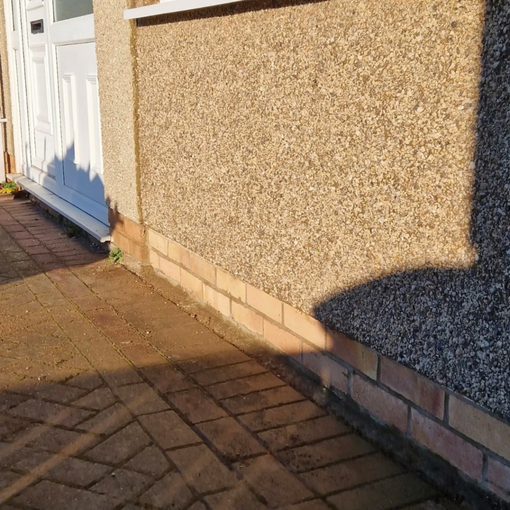 Pebbledashed close up of side of house