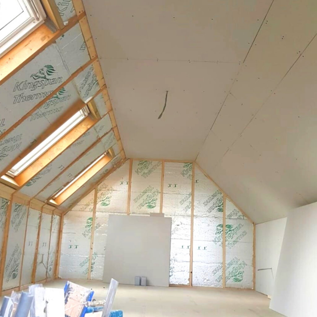 Bare insulated walls with half of the room plasterboarded